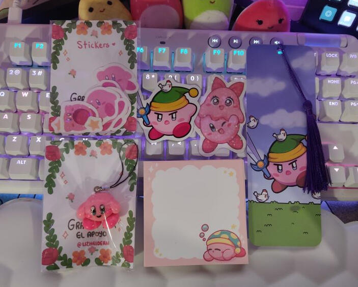 Paquete colguije Kirby $300. Incluye un memopad de 60 hojas, stickers holográficos, un separador, un iman para refrigerador y un colguije de arcilla de Kirby.